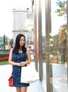 Happy Asia Chinese Eastern oriental young trendy woman girl shopping in mall with bags look at shopping window on street city Royalty Free Stock Photo