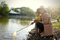 Happy Asia Chinese little boy toddler child play with his mother mom by lake holding string net catch fish carefree childhood Royalty Free Stock Photo