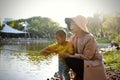 Happy Asia Chinese little boy toddler child play with his mother mom by lake holding string net catch fish carefree childhood Royalty Free Stock Photo