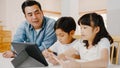 Happy Asia family homeschooling, father teach children using digital tablet in living room at home. Spending time together, Self-