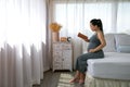 Happy Asia pregnant woman reading book and sitting on white bed Royalty Free Stock Photo