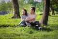 Happy asian adult man and cute child girl with love,hugging and smiling in summer nature,father and little beautiful daughter