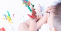 Happy asian baby child use paintbrush draw water color or fingerpaint on hand