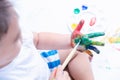 Happy asian baby child use paintbrush draw water color or fingerpaint on hand