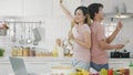 Couple husband and wife singing in kitchenware microphones in kitchen