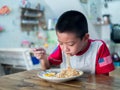 Happy Asian boy eating delicious noodle