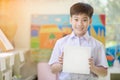 Happy asian boy hand holding blank paper board and looking at ca Royalty Free Stock Photo