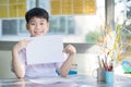 Happy asian boy hand holding blank A4 paper sheet and looking at Royalty Free Stock Photo