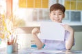 Happy asian boy hand holding blank A4 paper sheet and looking at Royalty Free Stock Photo