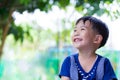 Happy asian boy looking up at park. Outdoors in the day time, tr Royalty Free Stock Photo