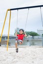 Happy asian boy swinging at the playground in the park Royalty Free Stock Photo