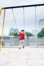 Happy asian boy swinging at the playground in the park Royalty Free Stock Photo