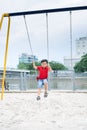Happy asian boy swinging at the playground in the park Royalty Free Stock Photo