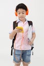 Happy Asian boy ware headphone and playing the cell phone . Royalty Free Stock Photo