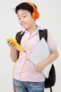 Happy Asian boy ware headphone and playing the cell phone . Royalty Free Stock Photo