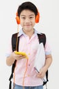 Happy Asian boy ware headphone and playing the cell phone . Royalty Free Stock Photo