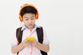 Happy Asian boy ware headphone and playing the cell phone .