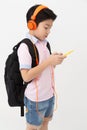 Happy Asian boy ware headphone and playing the cell phone . Royalty Free Stock Photo