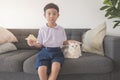 Happy Asian boy 6-7 years old, black-haired, fair-skinned, wearing a white shirt, blue shorts and his British Shorthair cat Royalty Free Stock Photo