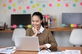 Happy Asian business woman in casual working with laptop and smile Royalty Free Stock Photo