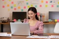 Happy Asian business woman in casual working with laptop and smile looking at camera at modern office Royalty Free Stock Photo