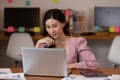 Happy Asian business woman in casual working with laptop and smile looking at camera at modern office Royalty Free Stock Photo