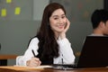 Happy Asian business woman working with laptop and smile looking at camera at modern office Royalty Free Stock Photo