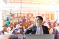 Happy asian businessman with beautiful smile drinking hot coffee during rest in blurred coffee shop background Royalty Free Stock Photo