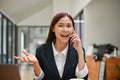 Happy asian businesswoman getting an excited news on the phone call, surprising phone call Royalty Free Stock Photo