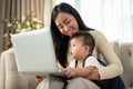 A happy Asian businesswoman mom is working from home and taking care of her naughty baby boy Royalty Free Stock Photo