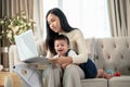 A happy Asian businesswoman mom is working from home and taking care of her naughty baby boy Royalty Free Stock Photo