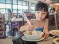 Happy Asian child eating delicious noodle with chopstick