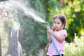 Happy asian child girl help parent washing car on water splash