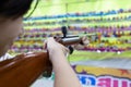 Happy asian child girl holding wooden gun,aim to the point,shooting the target,female playing shooting games for a carnival at Royalty Free Stock Photo