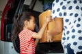 Happy asian child girl and mother helping to carry a cardboard box with stuffs moving into the car together to relocation Royalty Free Stock Photo