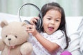 Happy asian child girl playing with her teddy bear