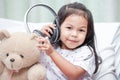 Happy asian child girl playing with her teddy bear