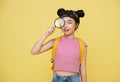 Happy Asian child girl student holding magnifying glass and looking at camera with curious expression  on yellow Royalty Free Stock Photo