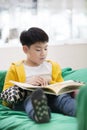 Happy asian child reading book with smile face. Royalty Free Stock Photo