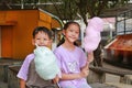 Happy Asian children boy and girl having fun eating cotton candy in the public park Royalty Free Stock Photo