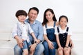 Happy Asian Chinese family sitting on the couch smiling