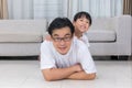 Happy Asian Chinese father and daughters lying on the floor Royalty Free Stock Photo