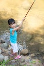 Happy Asian Chinese little girl angling with fishing rod Royalty Free Stock Photo