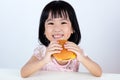 Happy Asian Chinese little girl Eating Burger Royalty Free Stock Photo