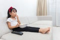 Happy Asian Chinese little girl eating popcorn on the sofa Royalty Free Stock Photo