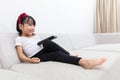 Happy Asian Chinese little girl holding a TV remote control Royalty Free Stock Photo