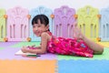 Happy Asian Chinese little girl laying on the floor coloring Royalty Free Stock Photo