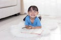 Happy Asian Chinese little girl lying on the floor drawing Royalty Free Stock Photo