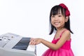 Happy Asian Chinese little girl playing electric piano keyboard