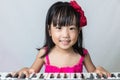 Happy Asian Chinese little girl playing electric piano keyboard Royalty Free Stock Photo